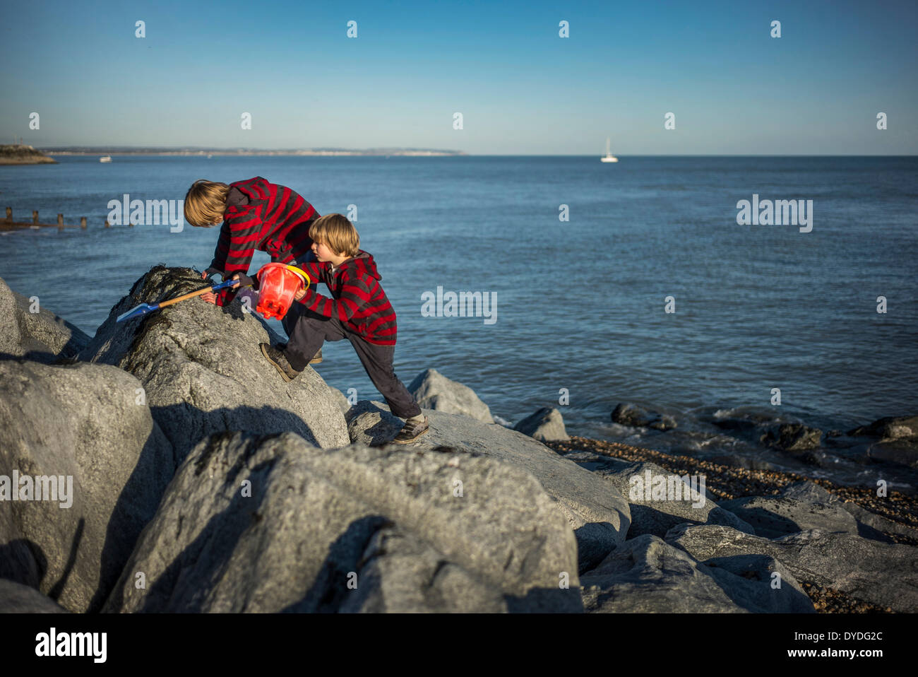 Deux garçons jouant sur les rochers à Eastbourne. Banque D'Images
