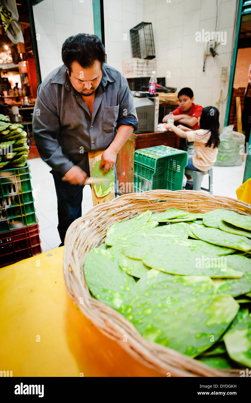 Un vendeur de préparer les palettes de cactus au Mercado de la Merced à Mexico. Banque D'Images