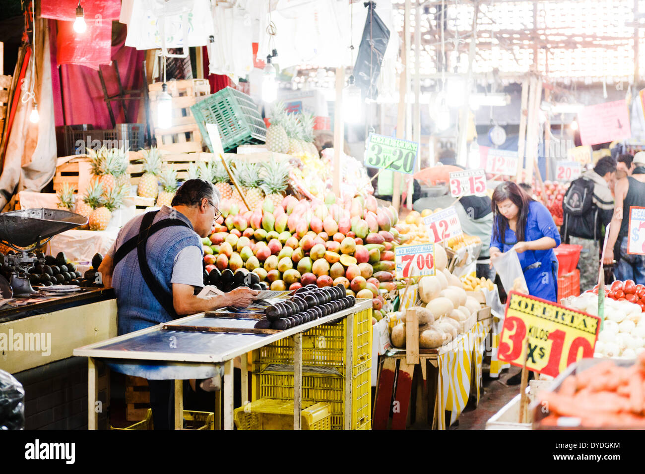 Un vendeur de fruits à la lecture du document le Mercado de la Merced à Mexico. Banque D'Images