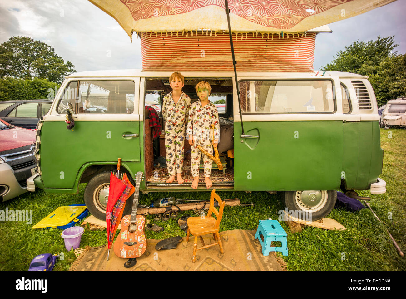 Deux garçons grincheux s'amusant dans un camping-car VW à un festival. Banque D'Images