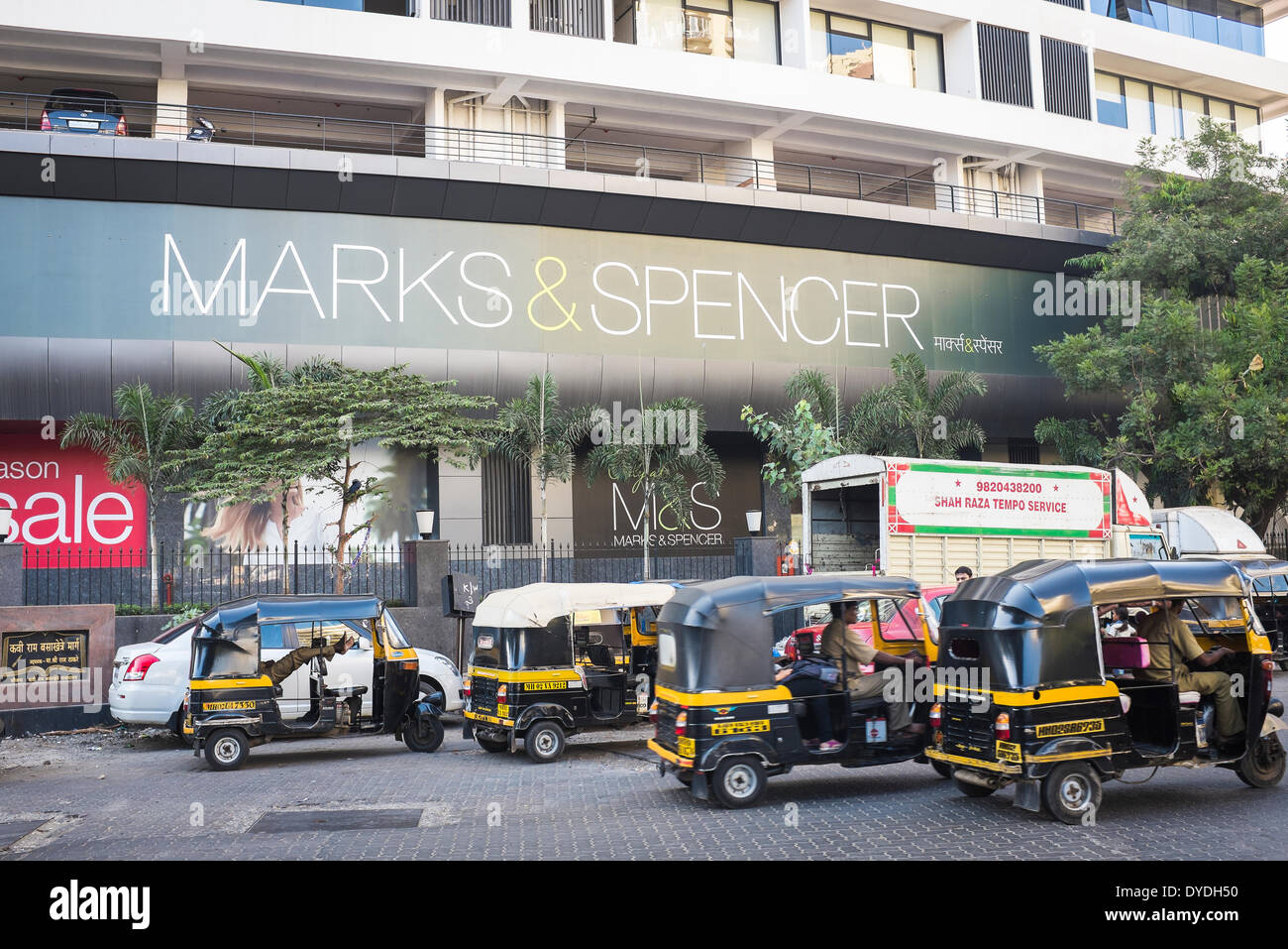 Pousse-pousse automatique et un camion de livraison à l'extérieur d'un magasin Marks and Spencer à Mumbai. Banque D'Images