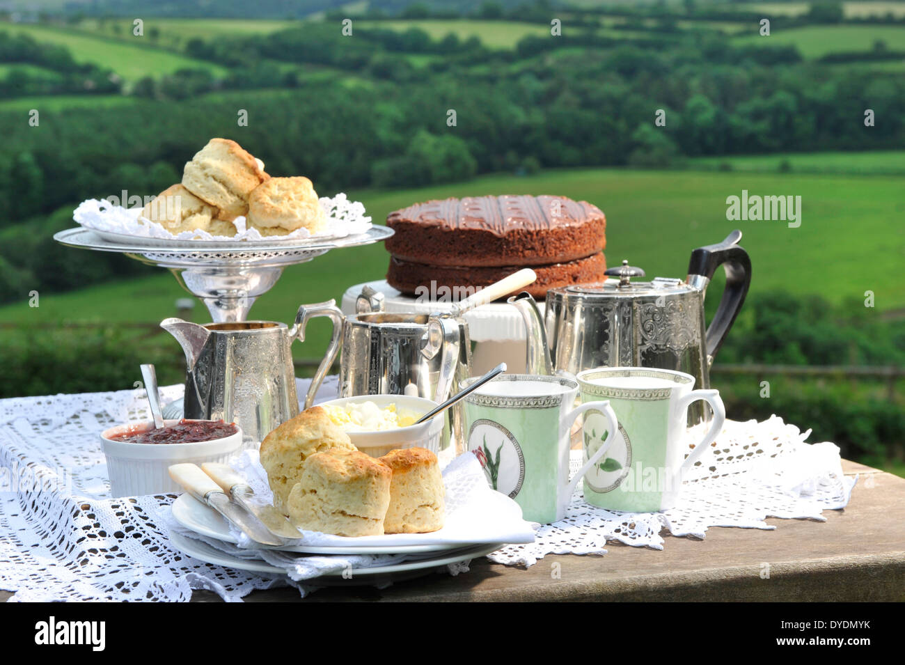 Un après-midi avec thé Devonshire cream crème caillée, confiture et un gâteau au chocolat avec les champs en arrière-plan UK Banque D'Images