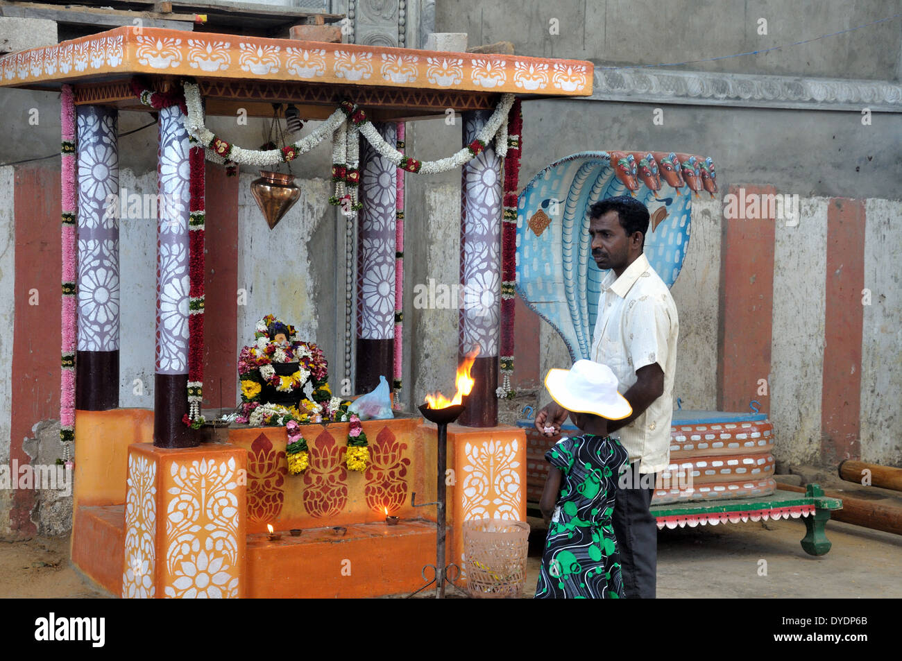 Homme et enfant faire une offrande à l'intérieur de Koneswaram Kovil, Trincomalee, Sri Lanka Banque D'Images