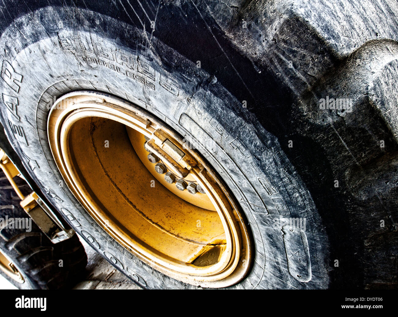 Gros plan des pneus et roues géantes sur un bulldozer montrant la saleté et l'usure sur les marches Banque D'Images