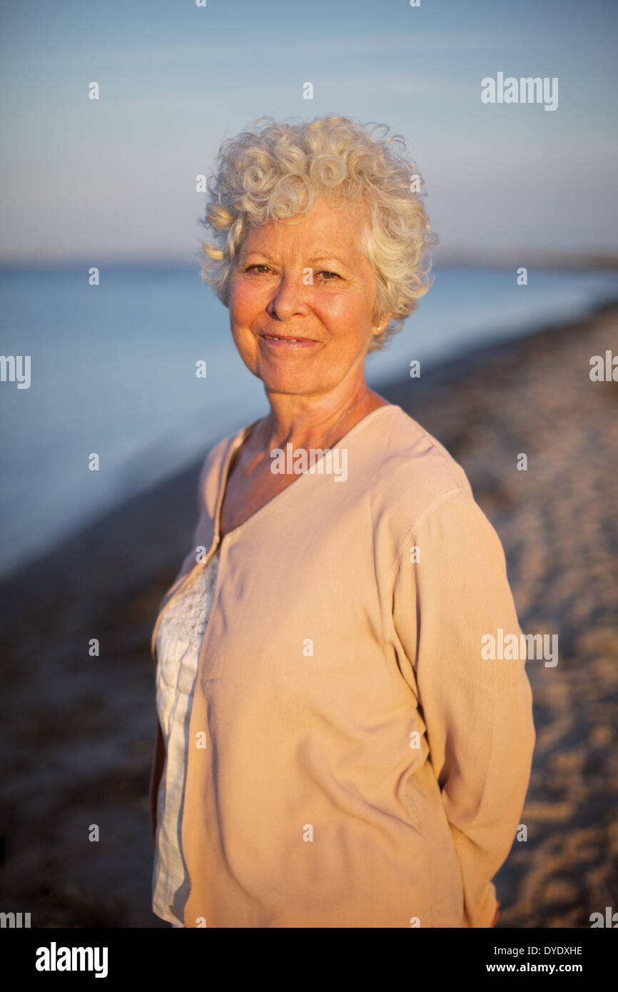 Portrait de vieille femme debout seul à la plage. Portrait dame de détente en plein air Banque D'Images