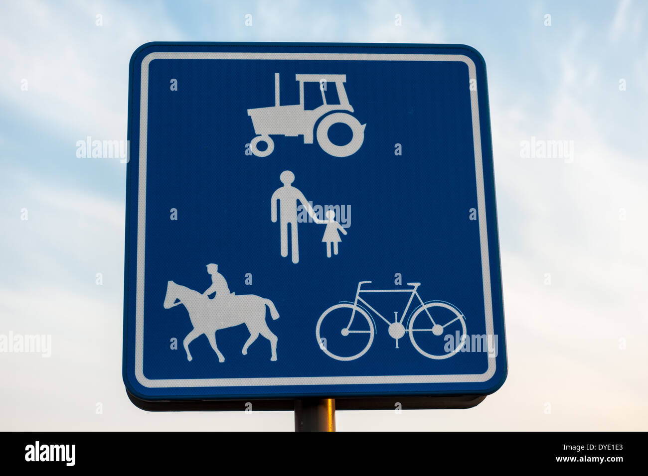 Une route avec un tracteur, les gens, le cheval et le cavalier, à vélo Banque D'Images