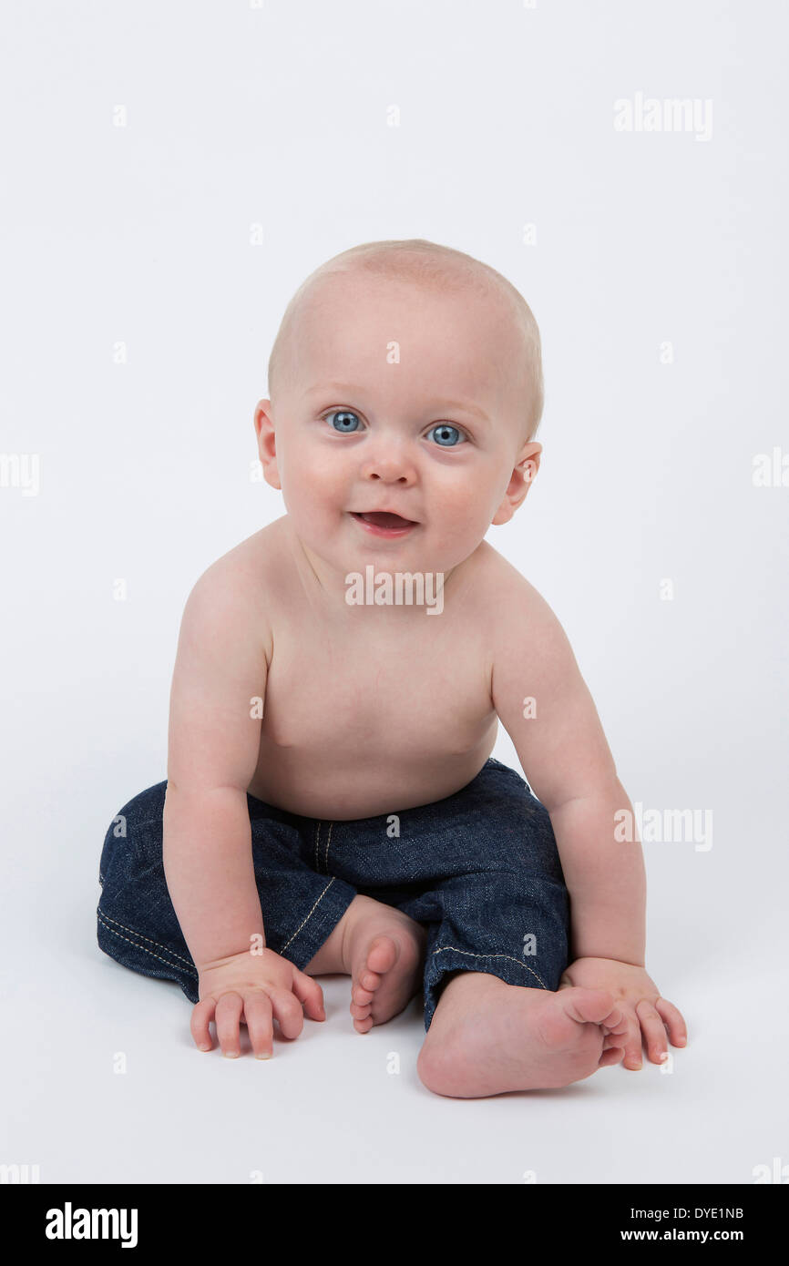 Heureux à l'âge de six mois, bébé garçon porter un jean bleu Banque D'Images
