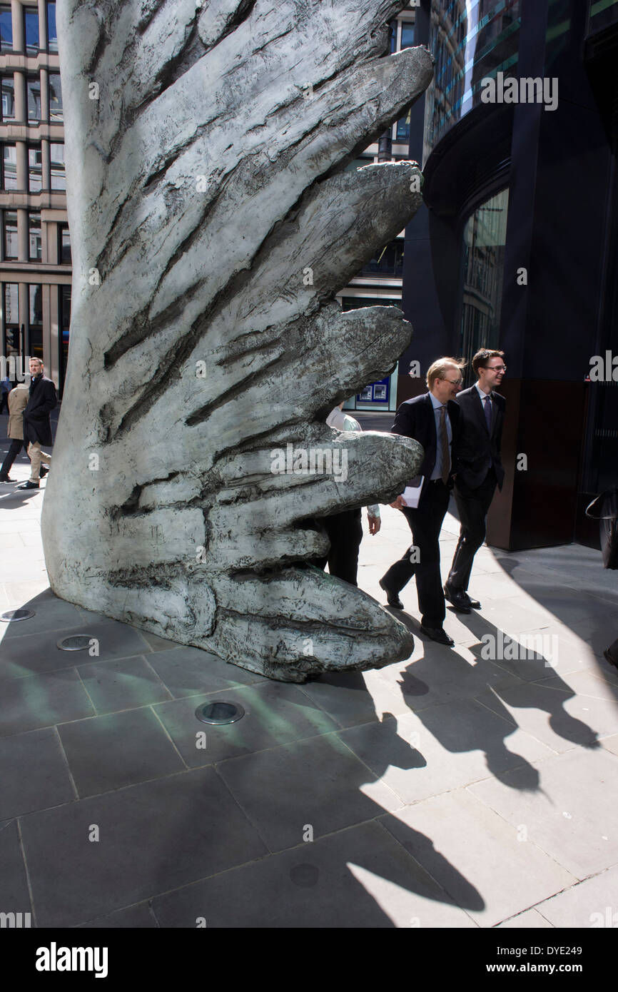 Les travailleurs de la ville par le passage de l'oeuvre d'un géant de l'aile de bronze lors d'un midi de printemps dans le quartier financier de Londres. Comme la lumière se reflète sur les immeubles de bureaux à proximité, la foule à l'heure du déjeuner devant ce géant des illustrations sur leur façon de réunions et sandwicheries. Les dix mètres de haut est la sculpture en bronze par le président de la Royal Academy of Arts, Christopher Le Brun, commandé par Hammerson en 2009. Elle est appelée 'La Ville' de l'aile et a été jeté par Morris Singer, fondateurs de l'art réputé pour être la plus ancienne fonderie d'art dans le monde. Banque D'Images