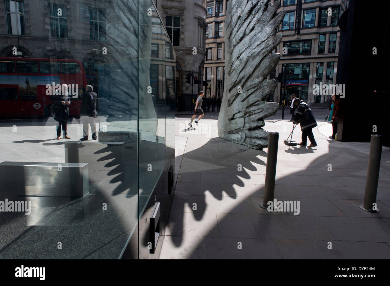 Les travailleurs de la ville par le passage de l'oeuvre d'un géant de l'aile de bronze lors d'un midi de printemps dans le quartier financier de Londres. Comme la lumière se reflète sur les immeubles de bureaux à proximité, la foule à l'heure du déjeuner devant ce géant des illustrations sur leur façon de réunions et sandwicheries. Les dix mètres de haut est la sculpture en bronze par le président de la Royal Academy of Arts, Christopher Le Brun, commandé par Hammerson en 2009. Elle est appelée 'La Ville' de l'aile et a été jeté par Morris Singer, fondateurs de l'art réputé pour être la plus ancienne fonderie d'art dans le monde. Banque D'Images