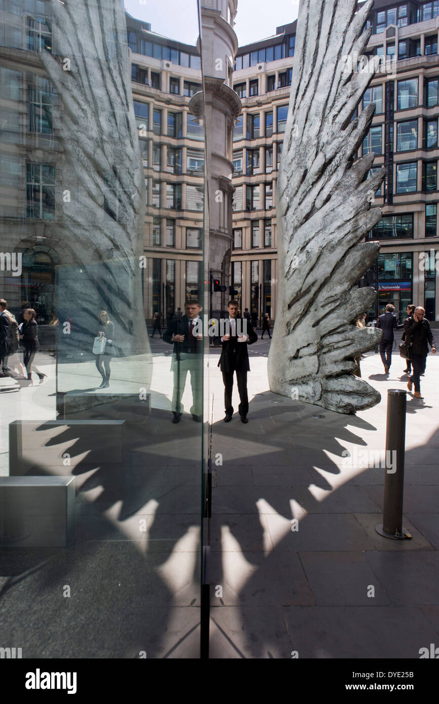 Les travailleurs de la ville par le passage de l'oeuvre d'un géant de l'aile de bronze lors d'un midi de printemps dans le quartier financier de Londres. Comme la lumière se reflète sur les immeubles de bureaux à proximité, la foule à l'heure du déjeuner devant ce géant des illustrations sur leur façon de réunions et sandwicheries. Les dix mètres de haut est la sculpture en bronze par le président de la Royal Academy of Arts, Christopher Le Brun, commandé par Hammerson en 2009. Elle est appelée 'La Ville' de l'aile et a été jeté par Morris Singer, fondateurs de l'art réputé pour être la plus ancienne fonderie d'art dans le monde. Banque D'Images
