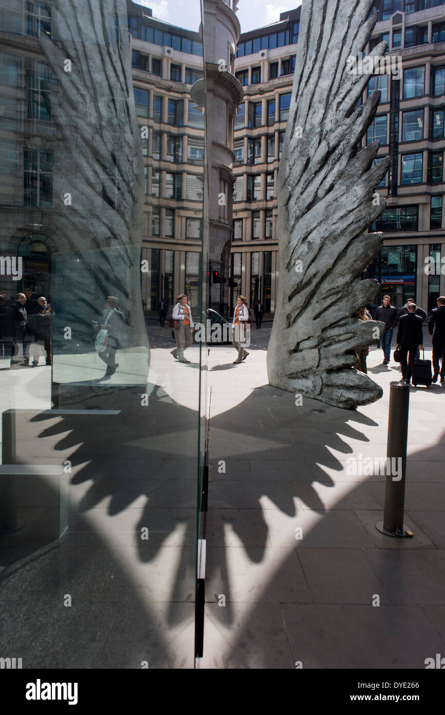 Les travailleurs de la ville par le passage de l'oeuvre d'un géant de l'aile de bronze lors d'un midi de printemps dans le quartier financier de Londres. Comme la lumière se reflète sur les immeubles de bureaux à proximité, la foule à l'heure du déjeuner devant ce géant des illustrations sur leur façon de réunions et sandwicheries. Les dix mètres de haut est la sculpture en bronze par le président de la Royal Academy of Arts, Christopher Le Brun, commandé par Hammerson en 2009. Elle est appelée 'La Ville' de l'aile et a été jeté par Morris Singer, fondateurs de l'art réputé pour être la plus ancienne fonderie d'art dans le monde. Banque D'Images