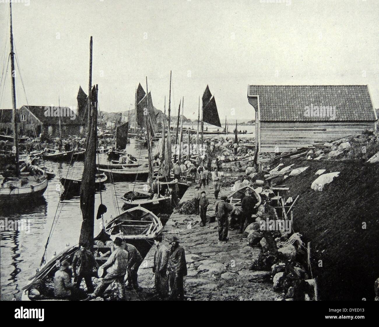 Photographie de pêcheurs norvégiens au quai de déchargement et chargement des bateaux. Du C. 1900 Banque D'Images