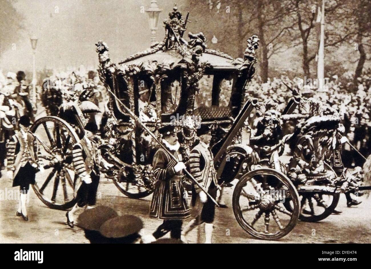Cette vue rapprochée montre le roi et la Reine dans l'État Coach comme il passe le long du remblai sur le voyage de retour au palais de Buckingham. Ils sont dans leurs robes de couronnement et l'accomplissement de leurs symboles de bureau. Banque D'Images