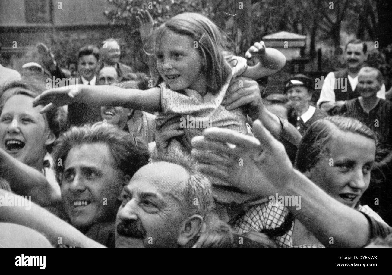 Une foule enthousiaste vague et saluer Adolf Hitler lors d'un défilé en 1934 Banque D'Images