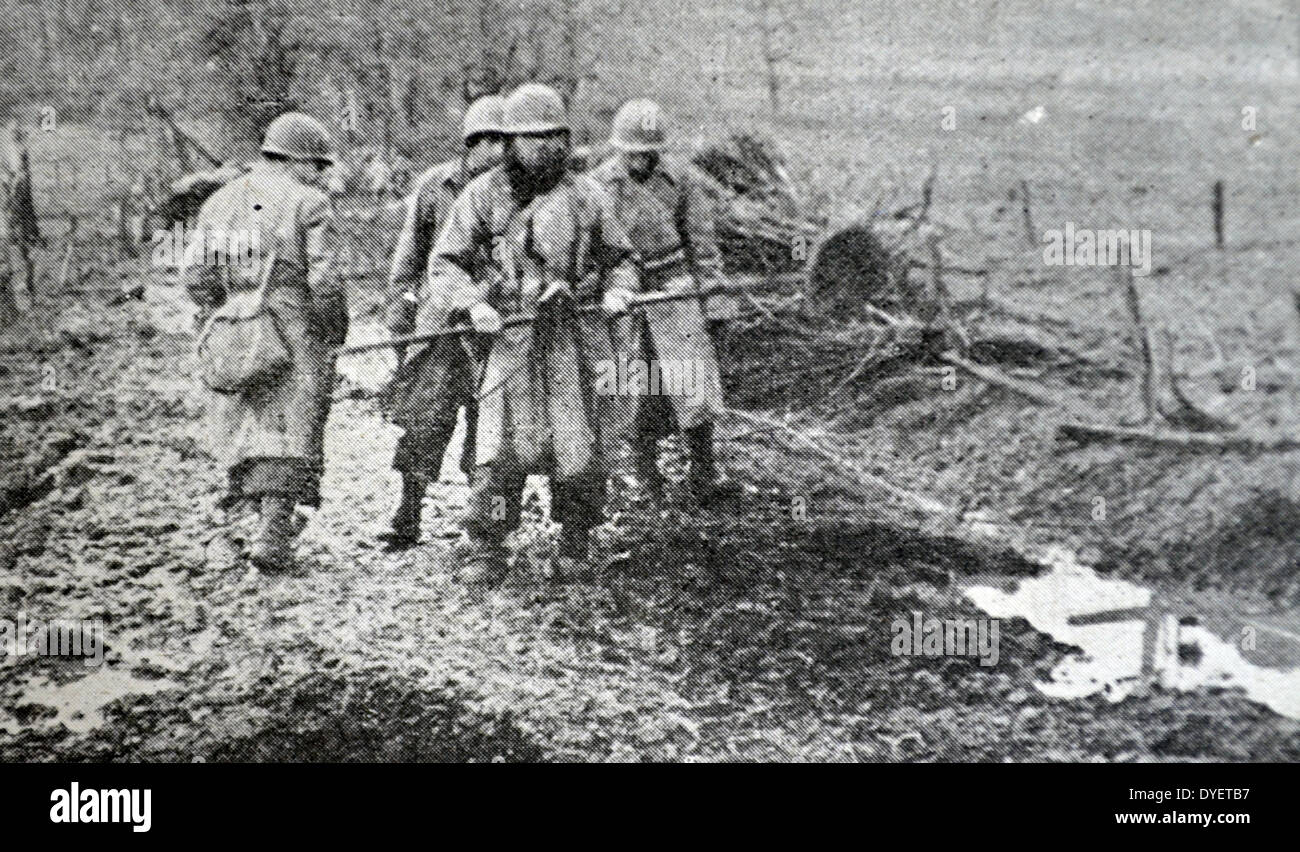 Les soldats américains de recherche soigneusement pour les mines à la suite de l'armée allemande en retraite en Alsace, France 1944 Banque D'Images
