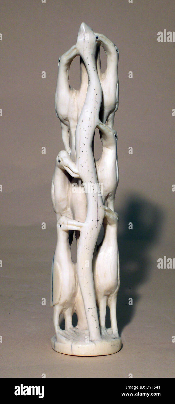 La sculpture de l'ivoire africain au début de six oiseaux attaquer un serpent. Banque D'Images