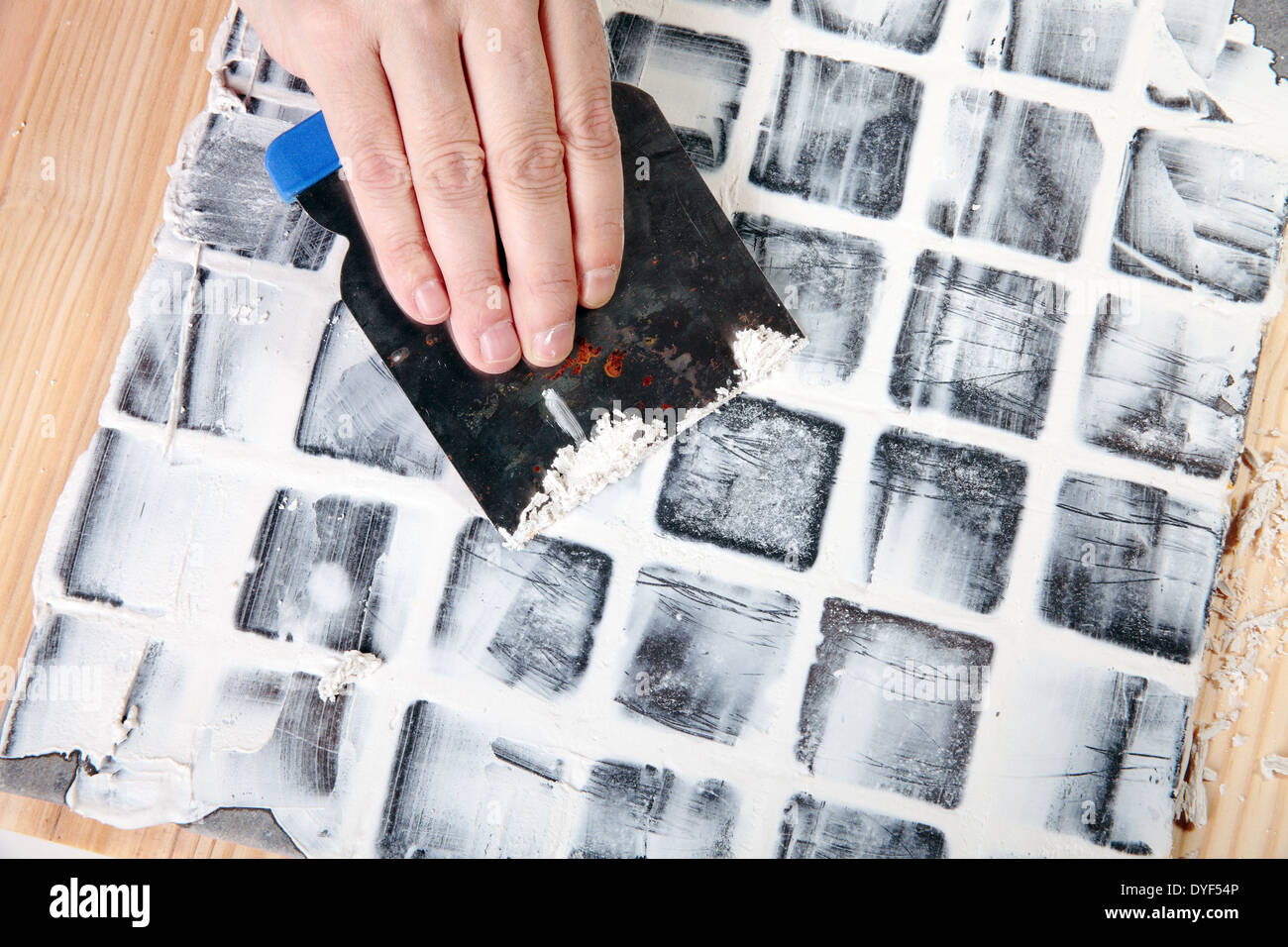 S'applique au travailleur de coulis carreaux gris Banque D'Images