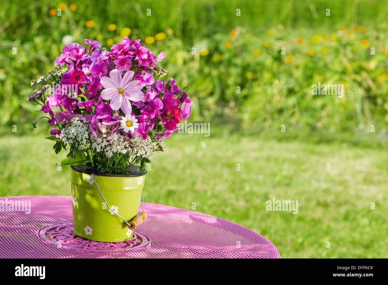 Fleurs d'été roses sur une table de jardin Banque D'Images