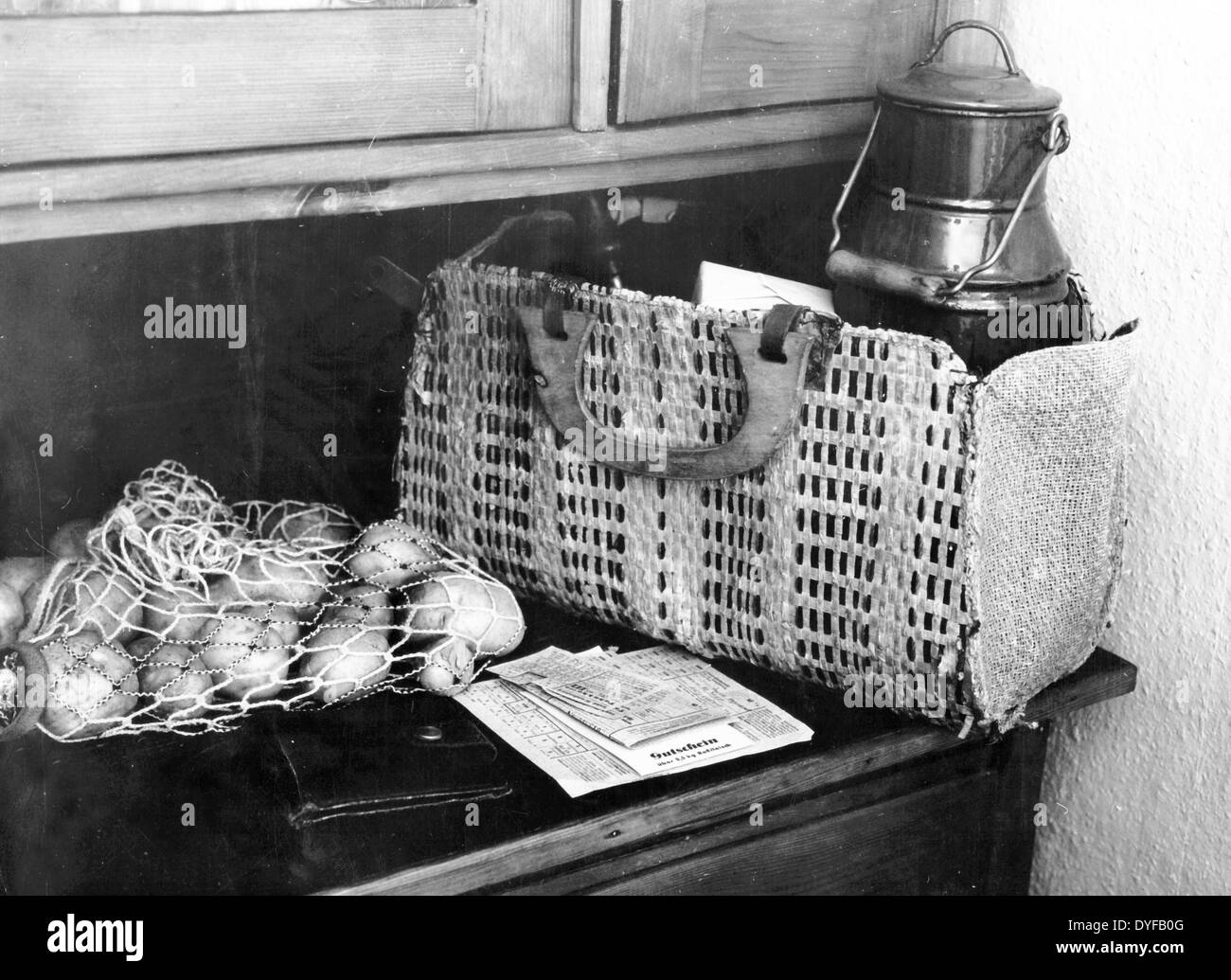 Un filet avec des pommes de terre, un portefeuille, des cartes de ration alimentaire, et un coupon pour un demi-kilo de boeuf de cheval se trouvent à côté d'un sac de shopping avec une boîte en métal à Berlin, en Allemagne, vers 1948. Fotoarchiv für Zeitgeschichtee - PAS DE SERVICE DE VIREMENT - Banque D'Images