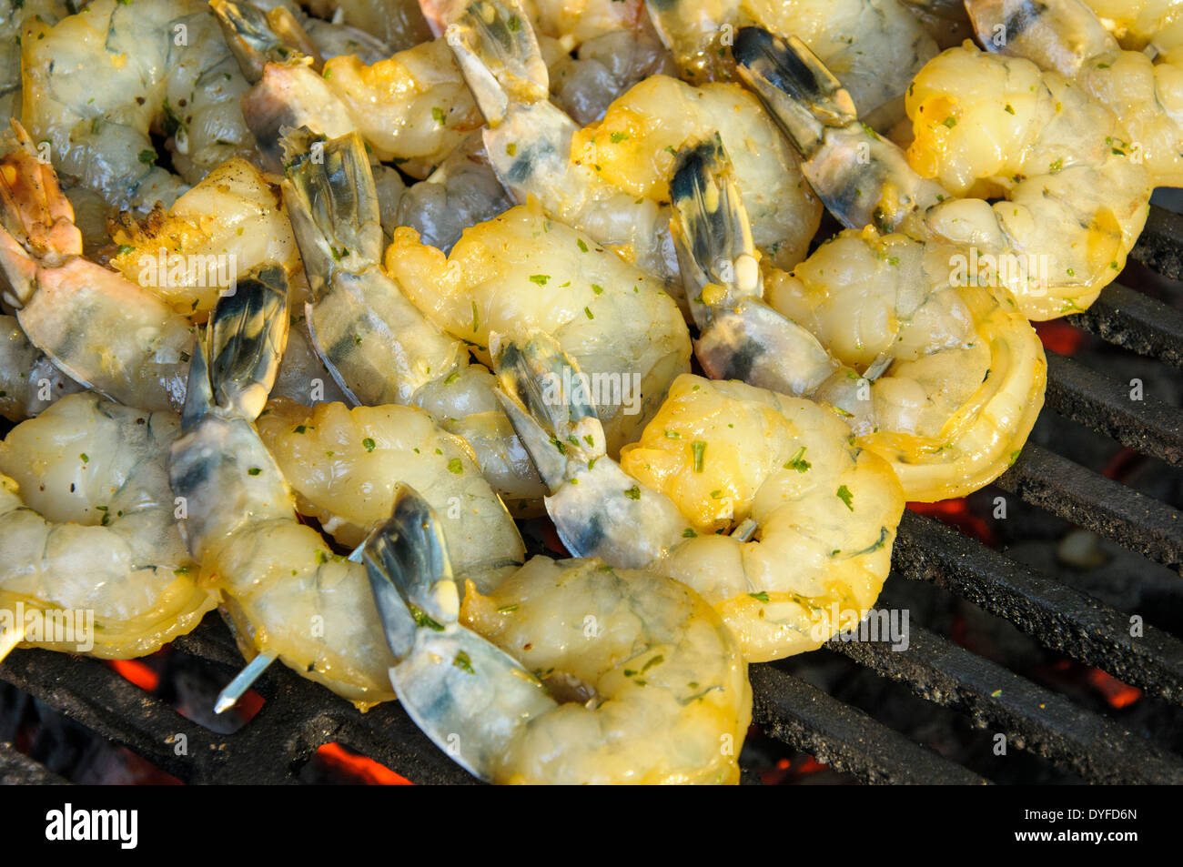 Les brochettes de crevettes cuites sur une petite flamme. Banque D'Images