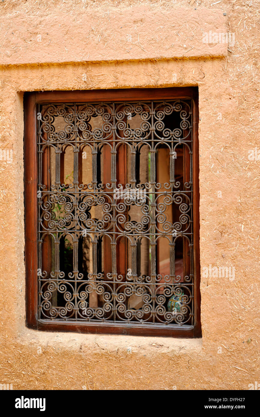 Dans la fenêtre de la ferronnerie décorative avec mur d'adobe, Maroc Banque D'Images