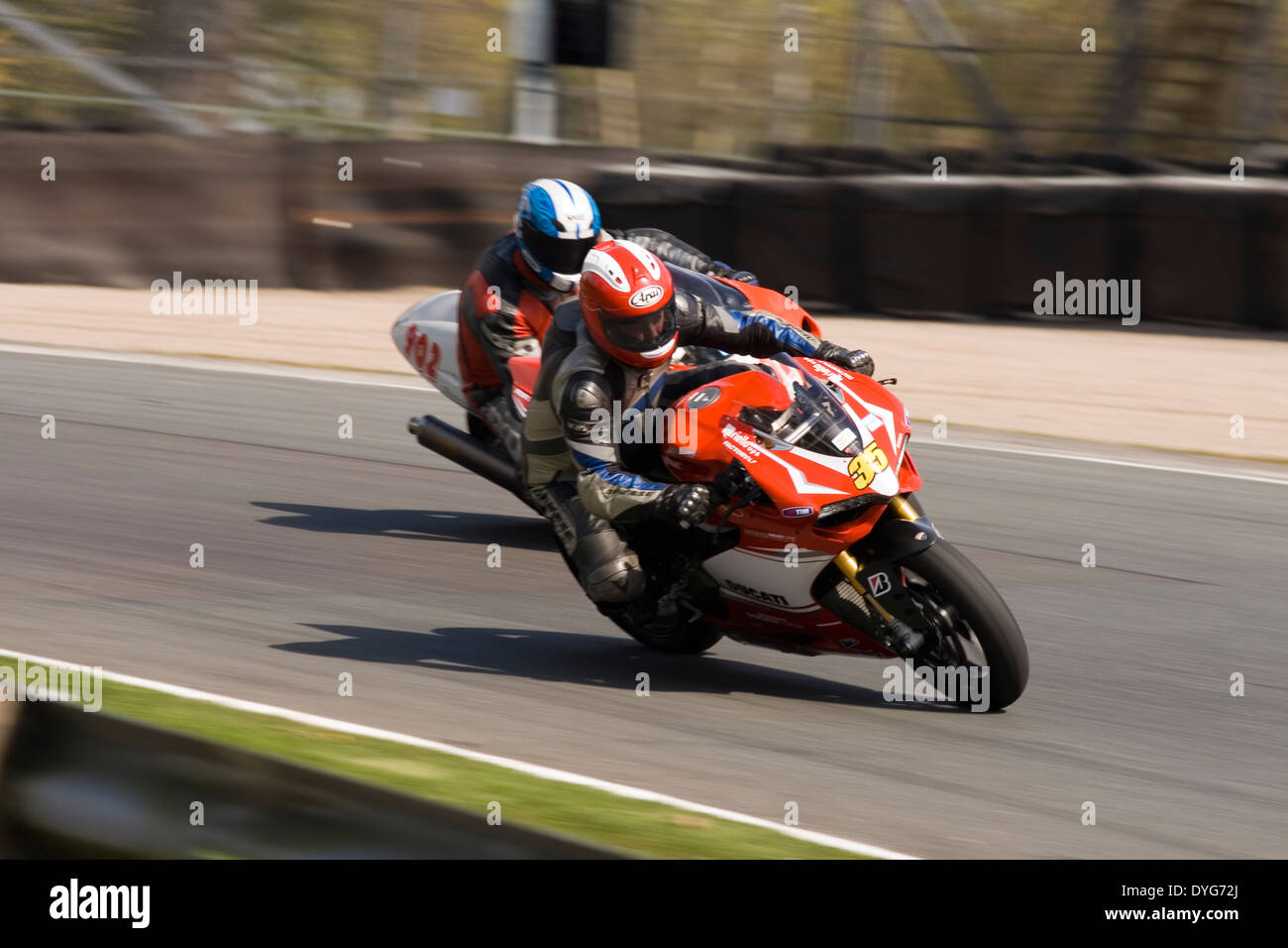 2 cavaliers pour moto racing par lodges coin à Oulton Park Race circuit. Banque D'Images