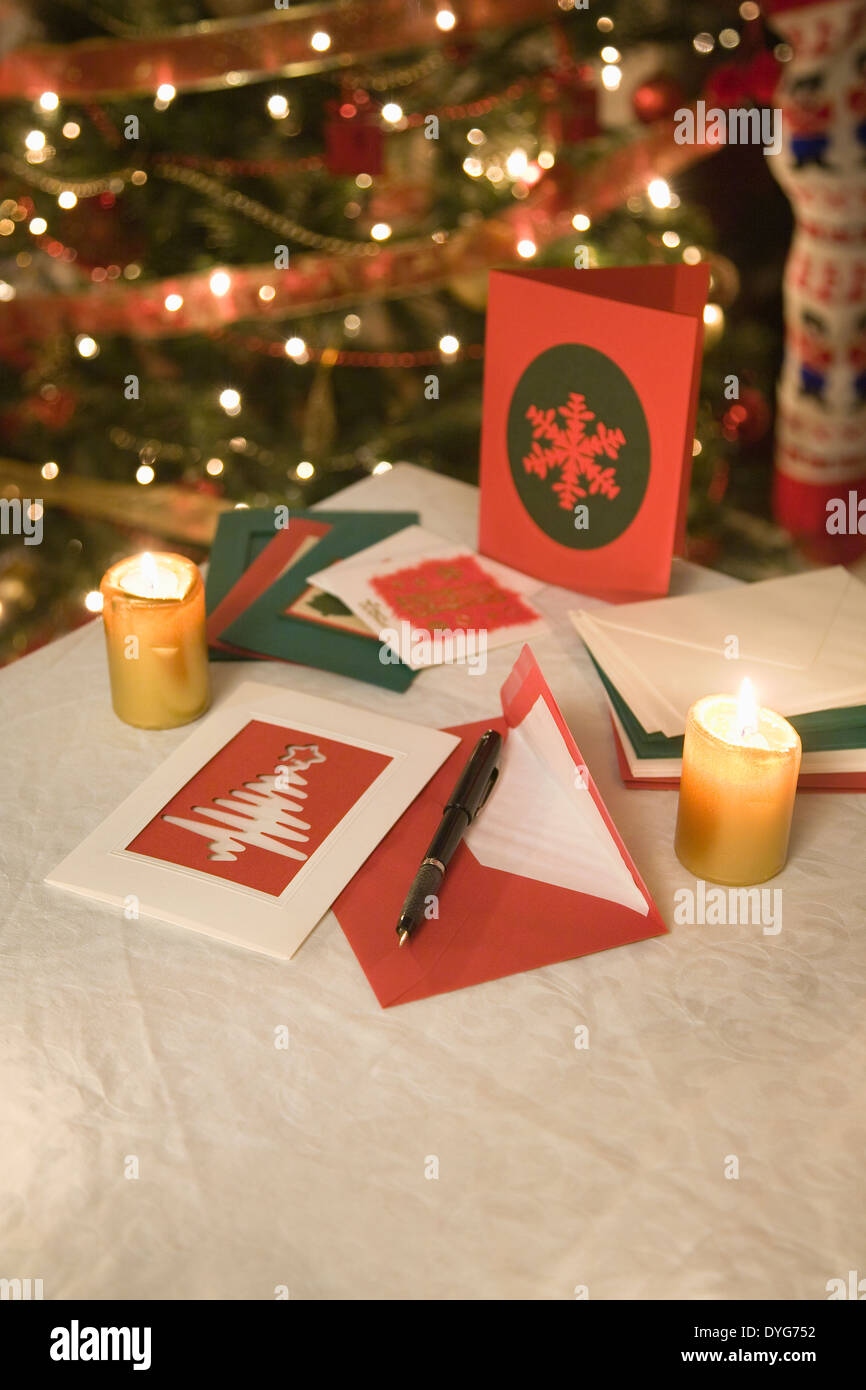 Sélection de cartes de Noël fait maison sur une table avec des enveloppes, des bougies et un stylo à encre Banque D'Images