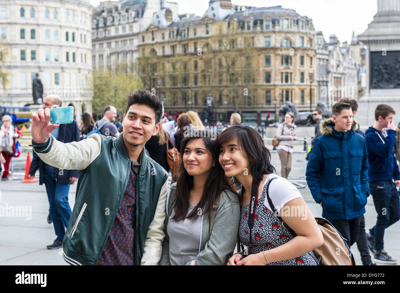 Un groupe de touristes posant pour une en selfies Trafalgar Square à Londres. Banque D'Images