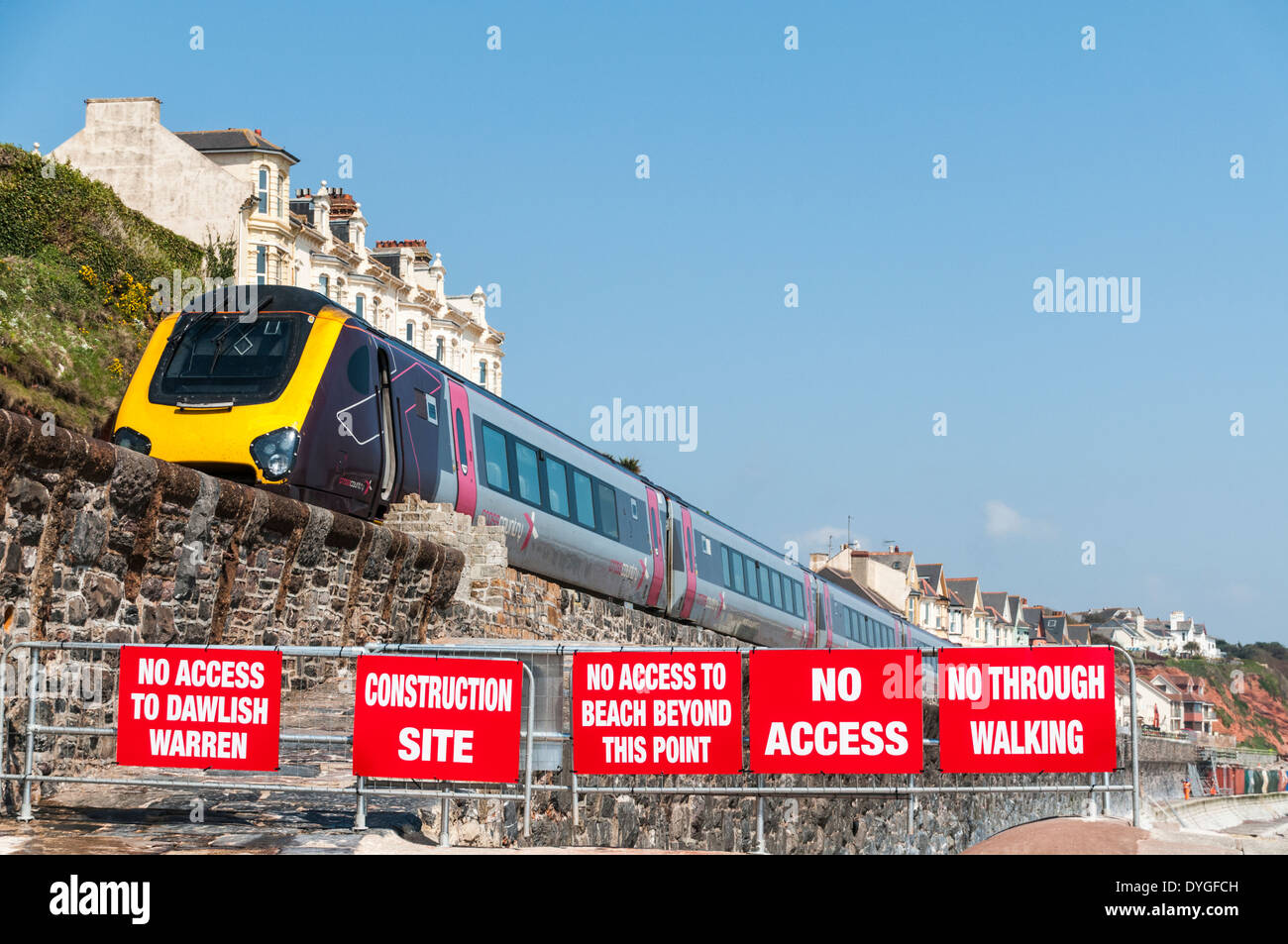 Cross Country express train de passer le long de la mer depuis le mur Dawlish signes d'empêcher l'accès à la digue endommagée Banque D'Images