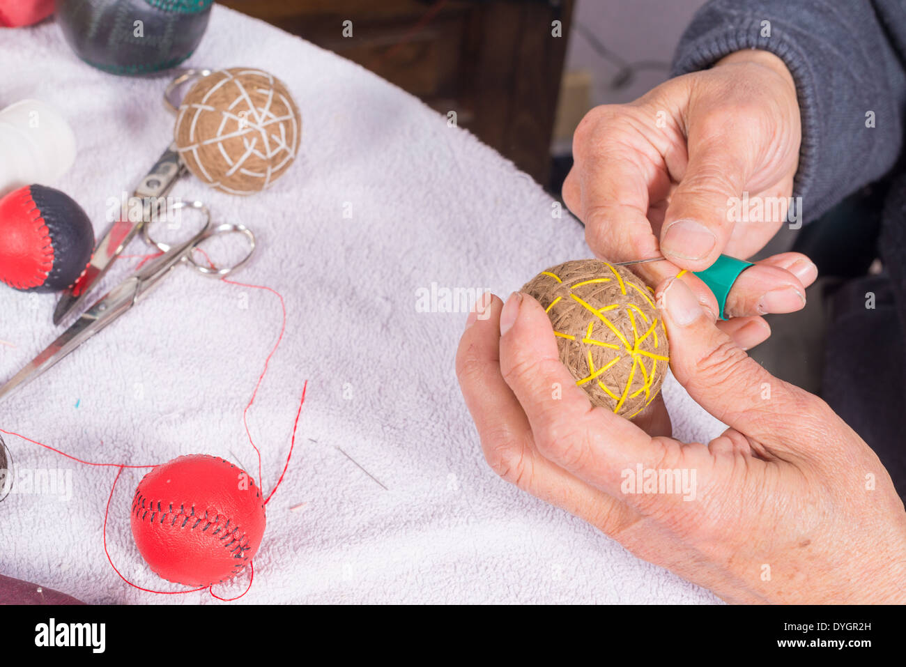 Les mains d'hommes traditionnels couture boules jai alai Banque D'Images