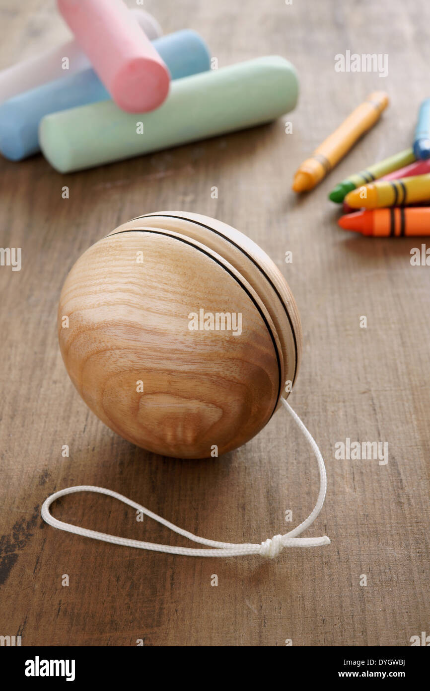 Un style ancien yoyo en bois avec craies et crayons de cire un concept d'enfance rétro Banque D'Images