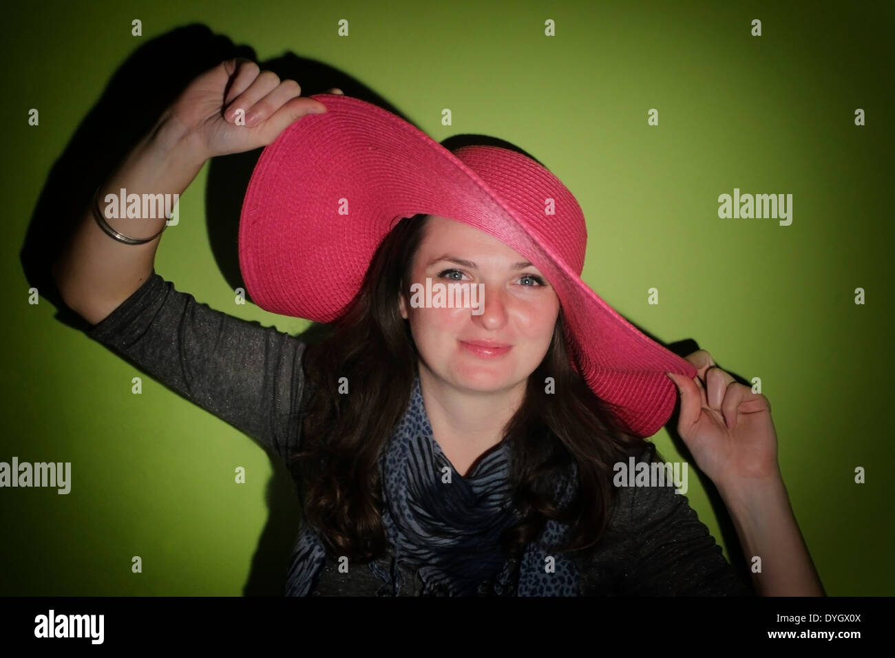Portrait d'une jeune femme avec chapeau de paille rose sur fond vert Photo  Stock - Alamy