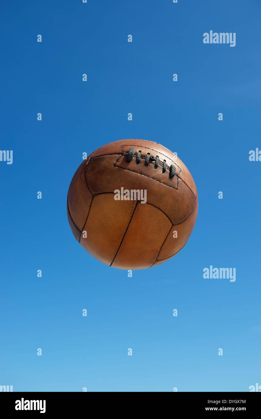 Vintage brown ballon de soccer football indéfinissable flottant dans un bleu ciel d'été Banque D'Images