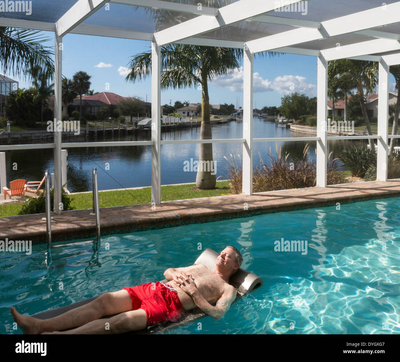 Homme mûr se prélasser dans une piscine, Punta Gorda, FL Banque D'Images