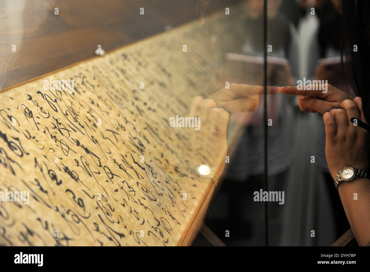 Hangzhou, Chine, Province de Zhejiang. 18 avr, 2014. Les pratiques d'un visiteur écrit caractères avec les doigts sur le verre à partir d'un travail de calligraphie au Musée Provincial de Zhejiang à Hangzhou, capitale de la Chine de l'est la province du Zhejiang, le 18 avril 2014. Une exposition présentant les œuvres de maîtres calligraphes et peintres célèbres dans la dynastie des Tang (618-907), dynastie Song (1127-1279) et Yuan (1271-1368) le coup d'ici vendredi. Elle va durer jusqu'au 18 mai. © Ju Huanzong/Xinhua/Alamy Live News Banque D'Images