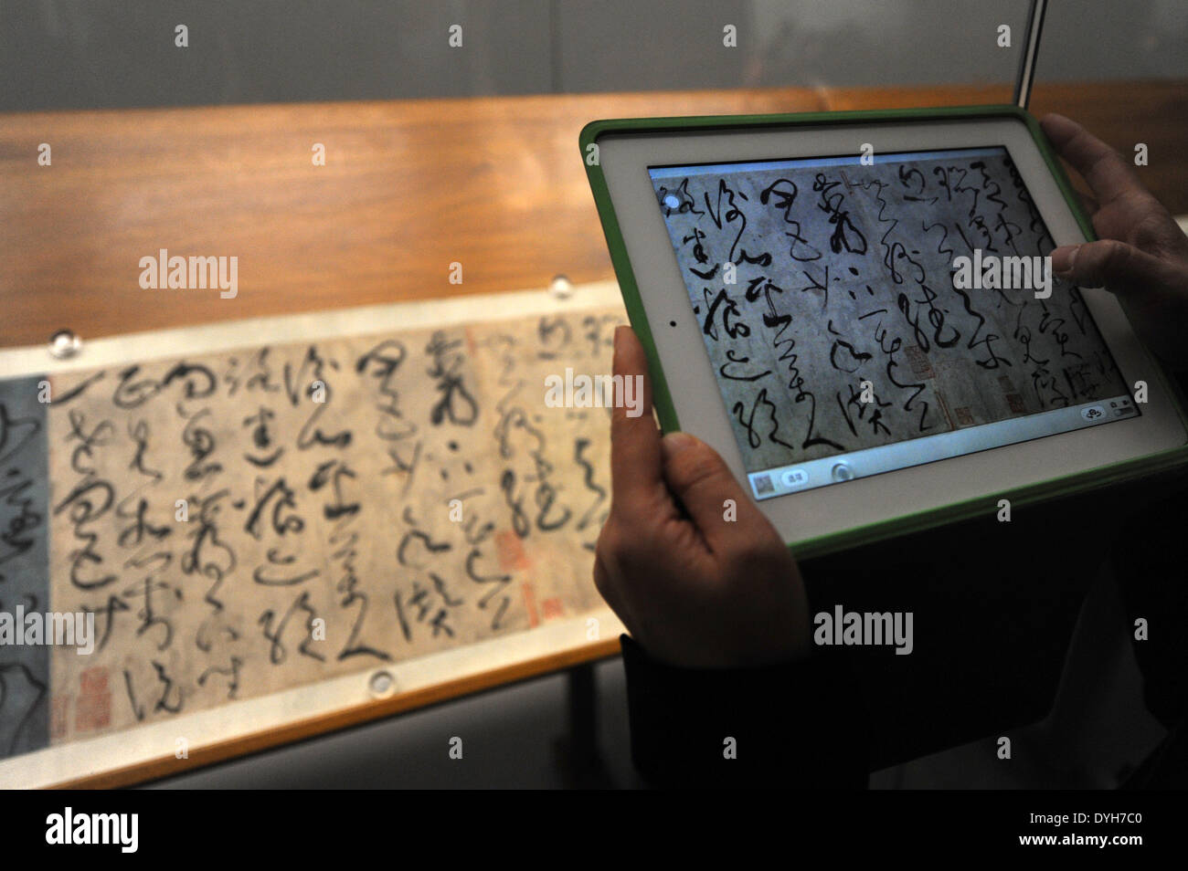 Hangzhou, Chine, Province de Zhejiang. 18 avr, 2014. Un visiteur prend des photos d'une œuvre de Zhang Xu, un célèbre calligrapheer dans la dynastie des Tang (618-907), au Musée Provincial de Zhejiang à Hangzhou, capitale de la Chine de l'est la province du Zhejiang, le 18 avril 2014. Une exposition présentant les œuvres de maîtres calligraphes et peintres célèbres dans la dynastie des Tang (618-907), dynastie Song (1127-1279) et Yuan (1271-1368) le coup d'ici vendredi. Elle va durer jusqu'au 18 mai. © Ju Huanzong/Xinhua/Alamy Live News Banque D'Images