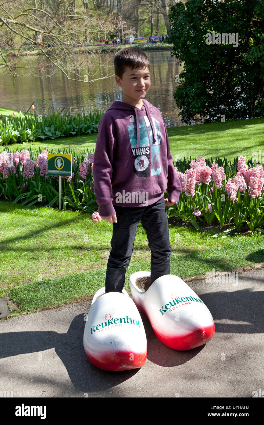 Petit garçon posant dans des chaussures en bois dans le Keukenhof à Lisse, aux Pays-Bas Banque D'Images