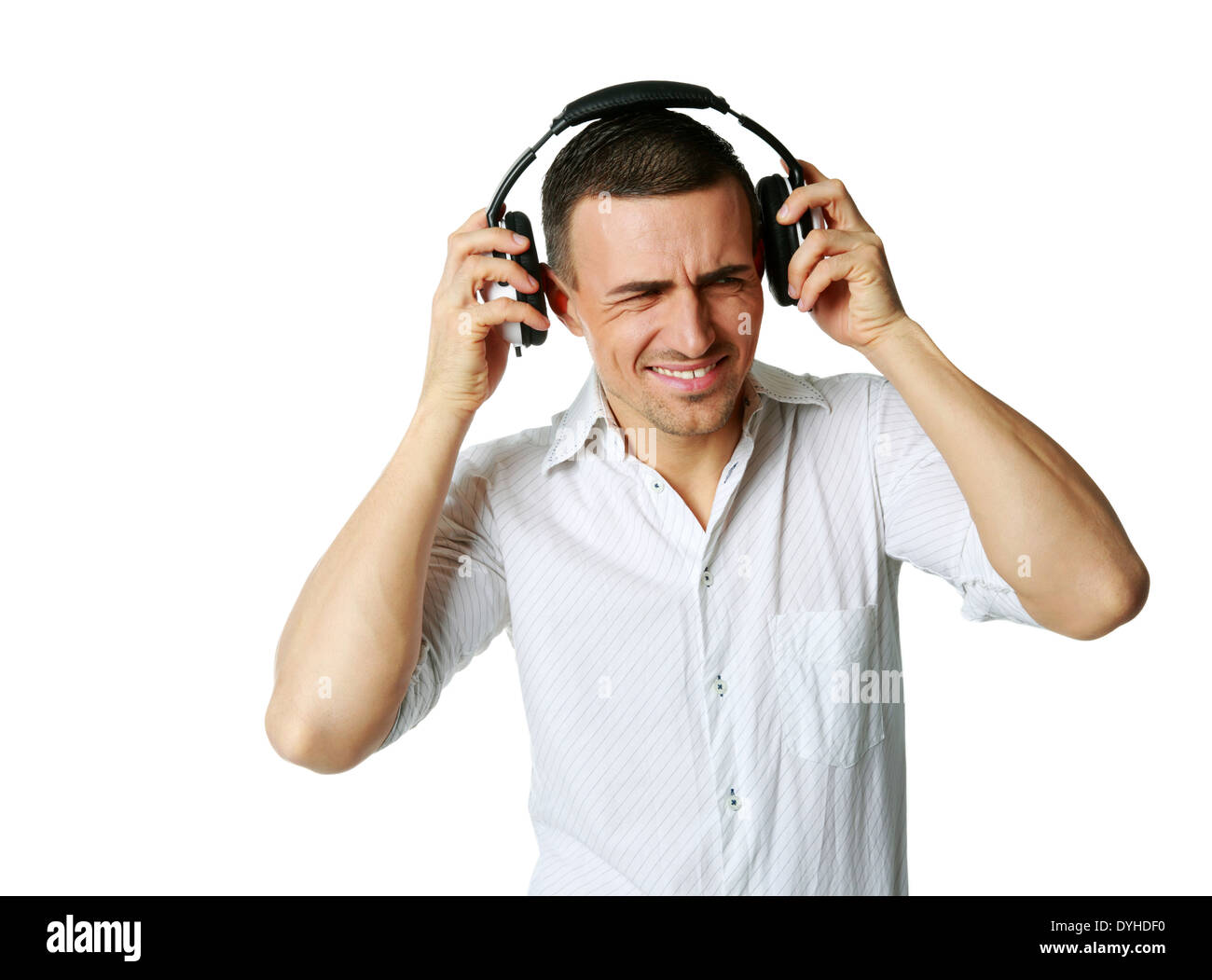 Un homme qui ne jouissent pas de ce qu'il c'est écouter, écouter de la musique sur fond blanc Banque D'Images