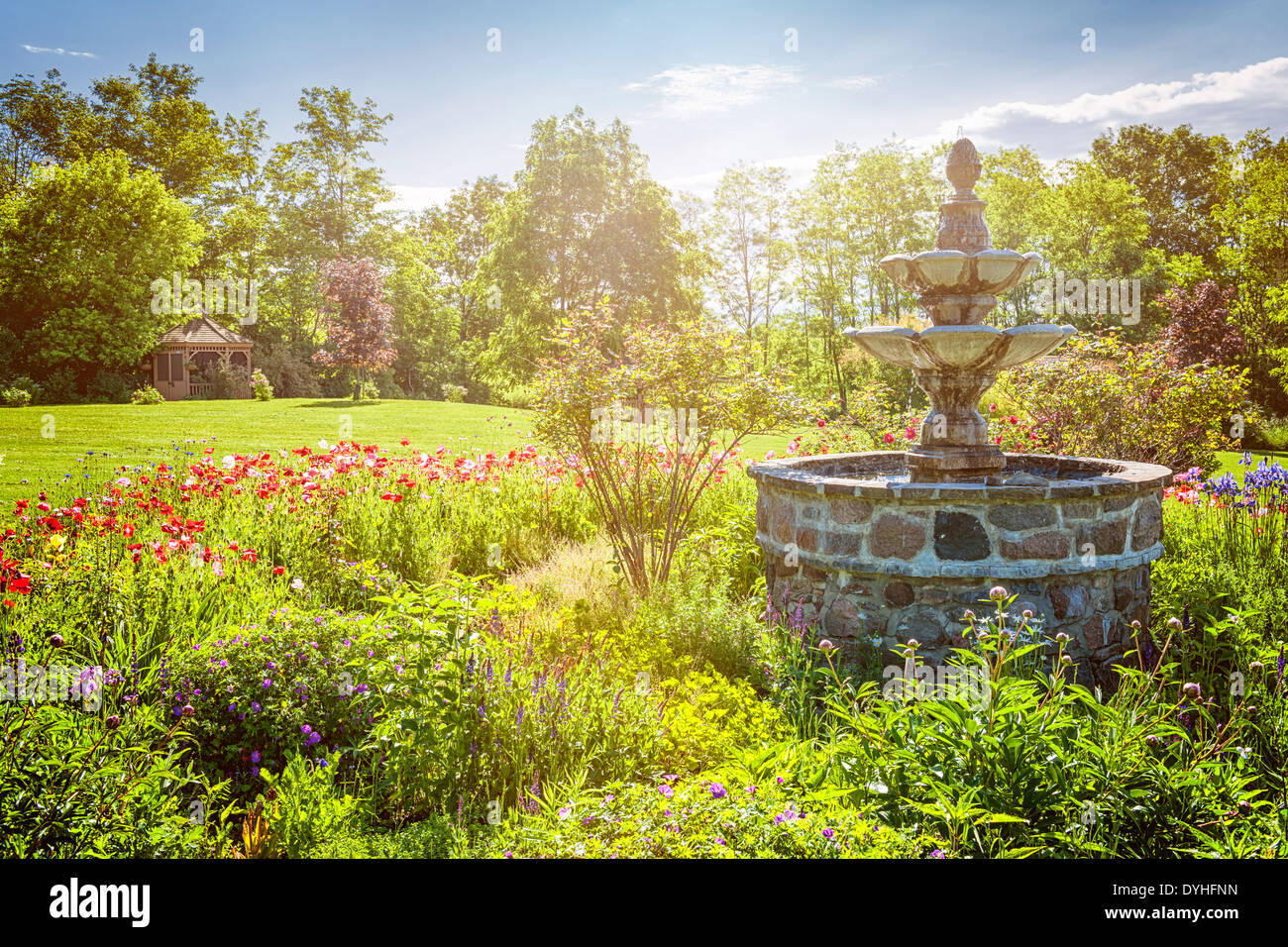 Jardin verdoyant avec fontaine en pierre et un belvédère en début de matinée. La Sainte Anne's Spa, Grafton, l'Ontario, Canada. Banque D'Images