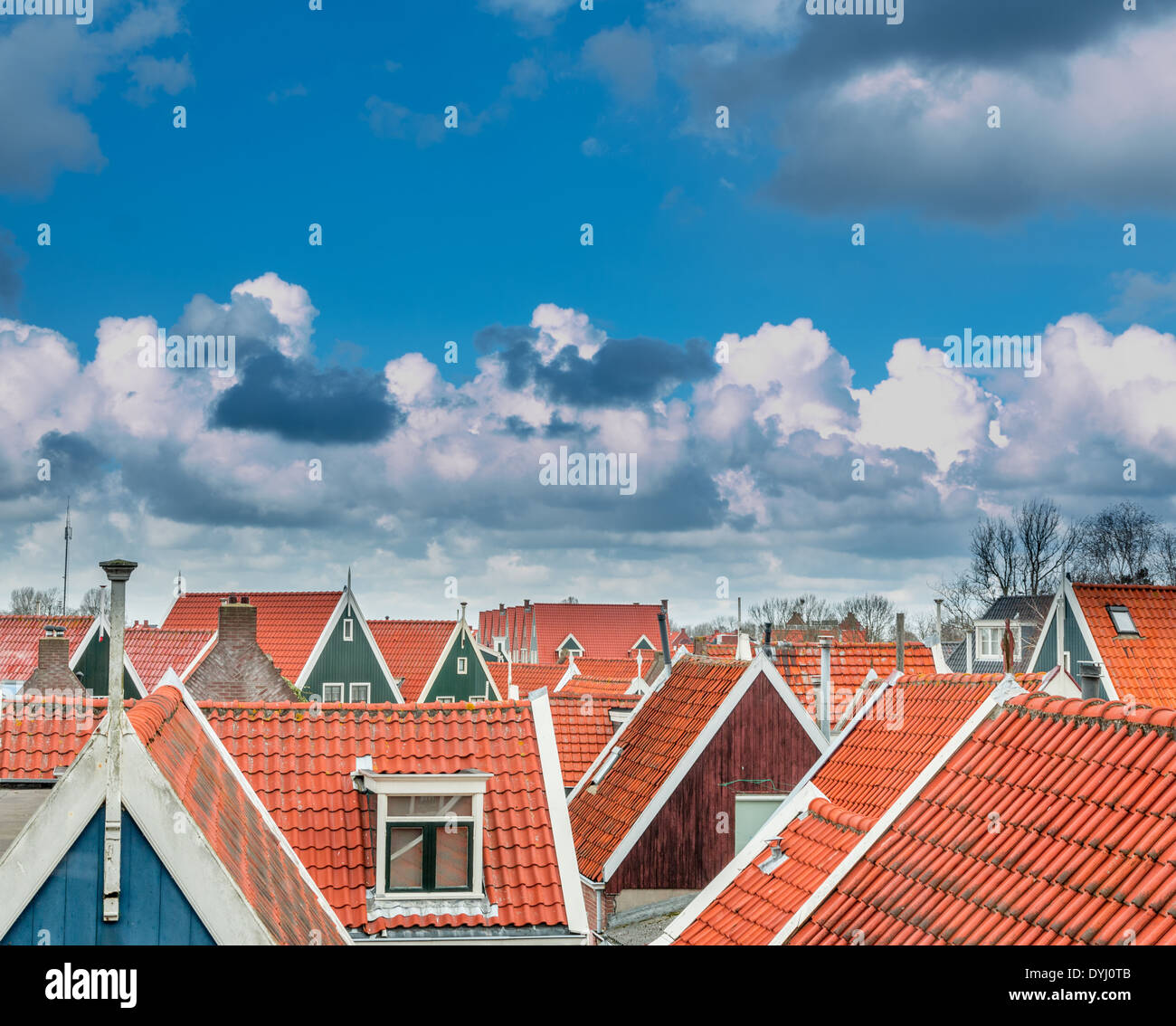 Nuages dans un beau ciel bleu accrocher au-dessus de toits de tuiles rouges dans une ville néerlandaise, le nord de la Hollande. Banque D'Images