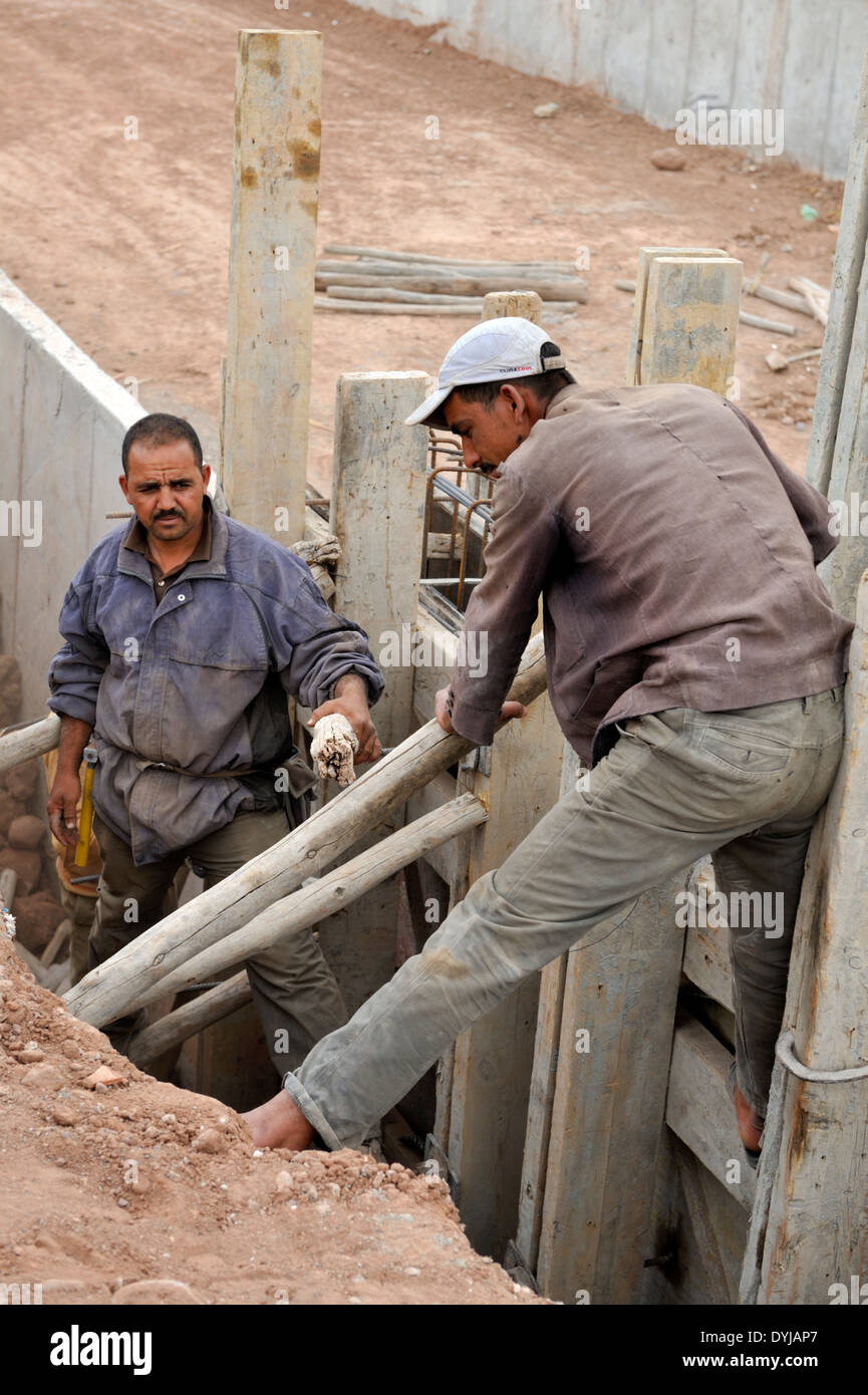 L'installation d'ouvriers de la construction bois traditionnelle pour coffrage de béton sur le nouveau canal pour l'approvisionnement en eau, Marrakech Maroc Banque D'Images