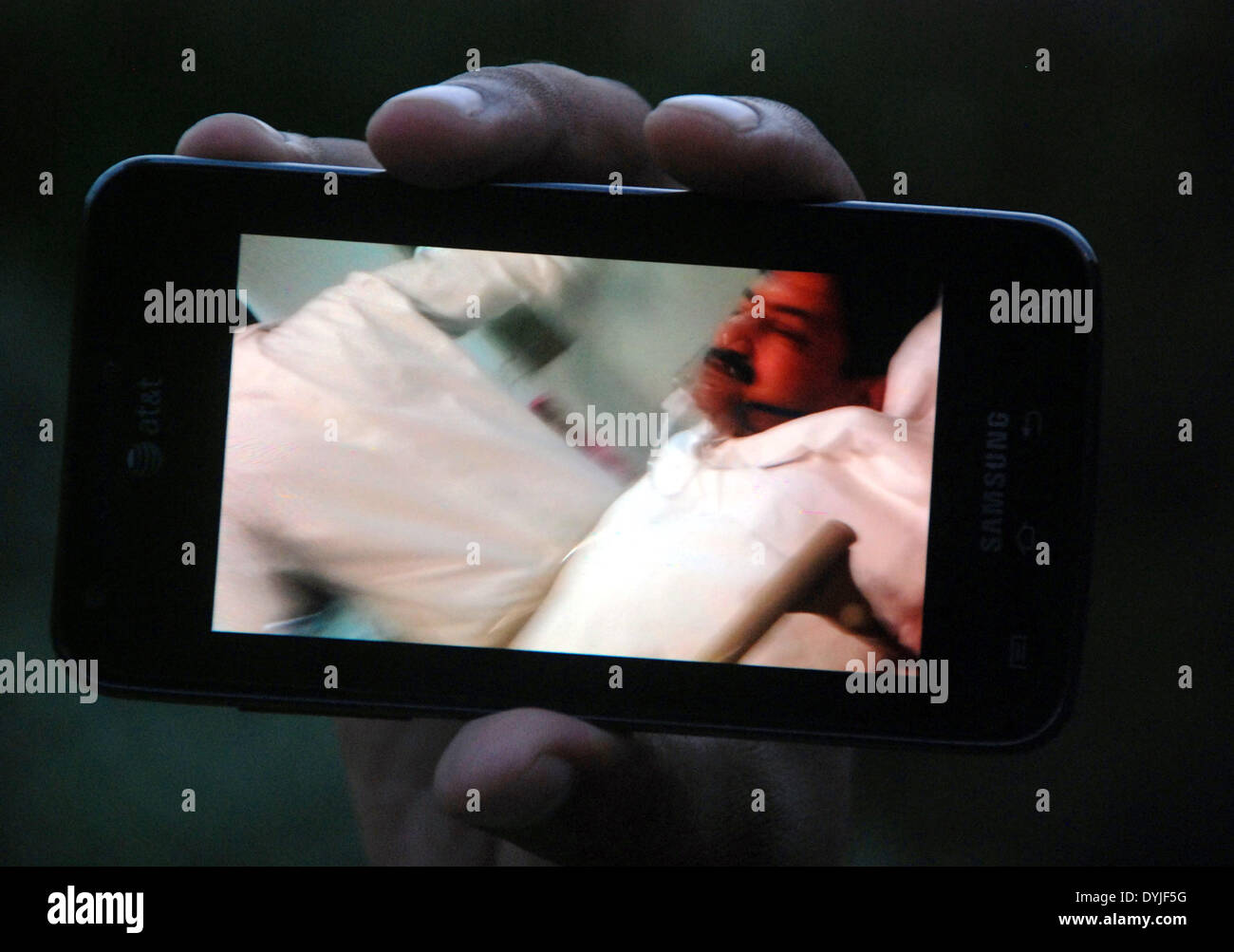 Karachi. Apr 19, 2014. Un homme montre l'image de journaliste blessé Hamid mir sur son téléphone mobile à un hôpital dans le sud de port pakistanais ville de Karachi le 19 avril 2014. Éminent journaliste pakistanais, anchorperson Hamid Mir est auraient été blessés après avoir été tourné à trois fois sur son chemin à l'aéroport de bureau à Karachi le samedi, les médias locaux ont rapporté. © Arshad/Xinhua/Alamy Live News Banque D'Images