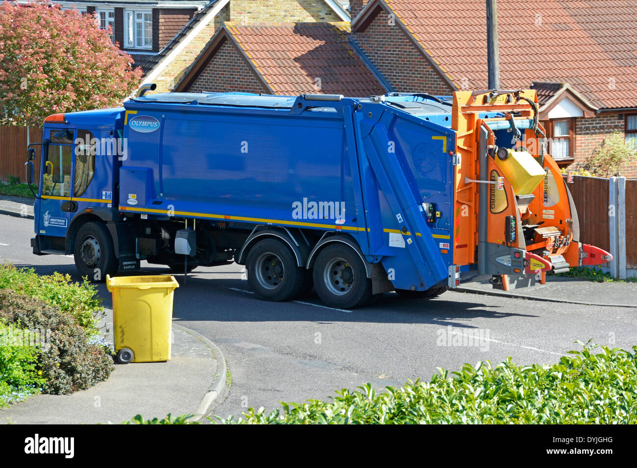 Brentwood Council vue latérale chariot bleu attendre dans la rue du village résidentiel ramasser les ordures ménagères dans des poubelles jaunes Essex Angleterre Royaume-Uni Banque D'Images