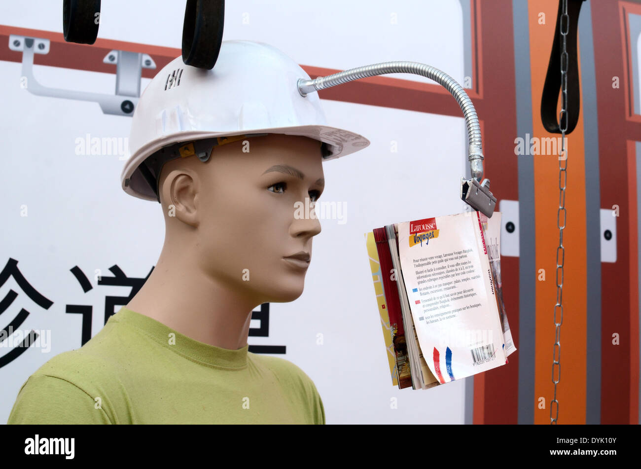 Train passager ou un homme portant un casque dur factice Gadget avec porte-livre sur le train. Gadget japonais inutile Chindogu ou Banque D'Images