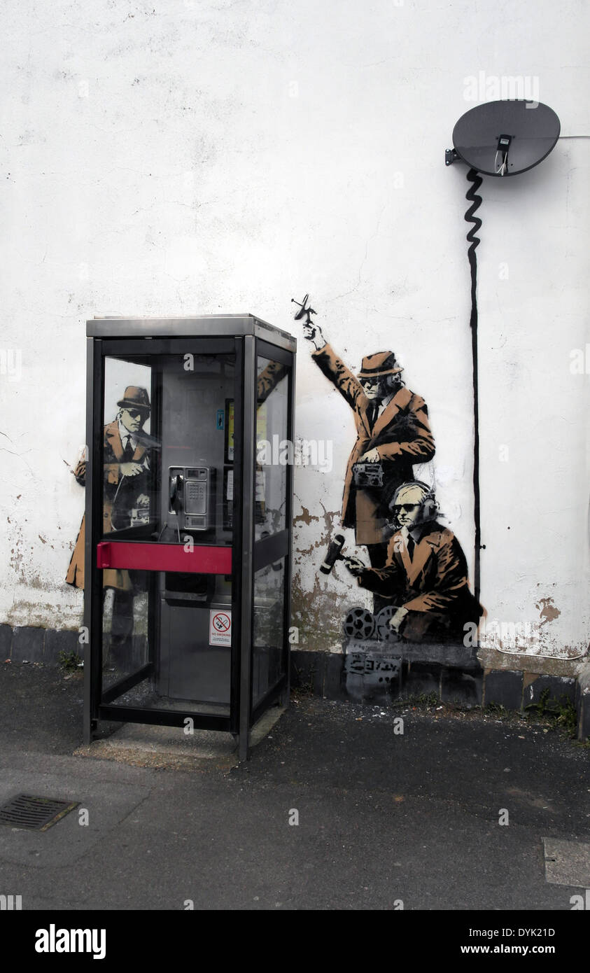 Cette pièce d'art de rue l'on pense être par Banksy, il dispose d'agents d'écoute de monde autour d'une cabine téléphonique. Il a été cr Banque D'Images