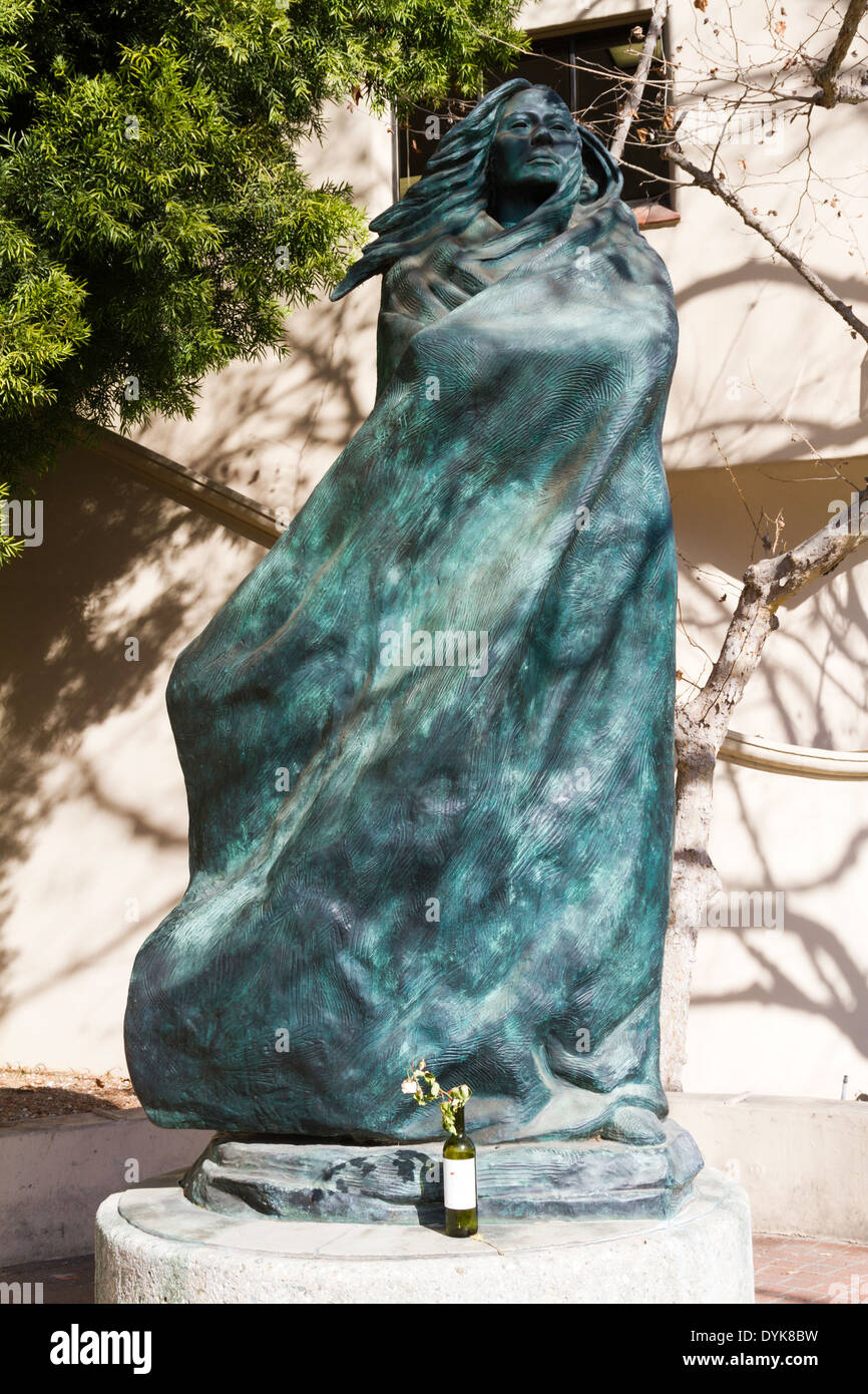 Statue de femme amérindienne avec memorial de fleurs fanées dans une bouteille de vin dans la région de Santa Barbara, en Californie. Banque D'Images