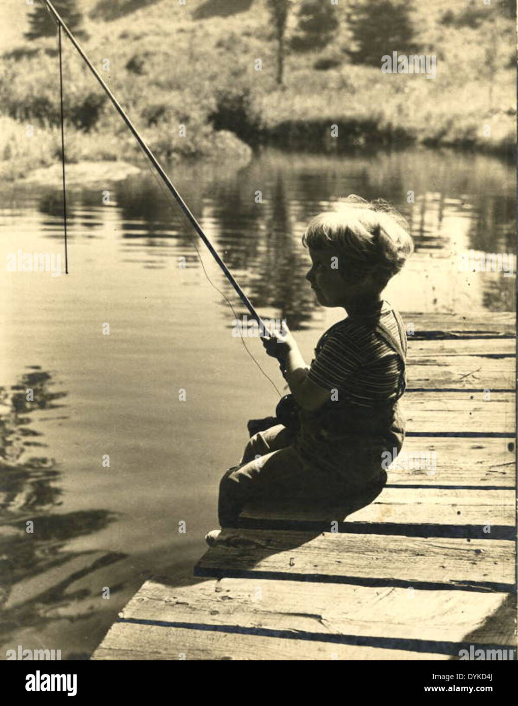 Lois Duncan, fille de Joseph Steinmetz, est montrée pêchant en Pennsylvanie, capturant un moment récréatif avec des canons à pêche le long d'un quai. Banque D'Images