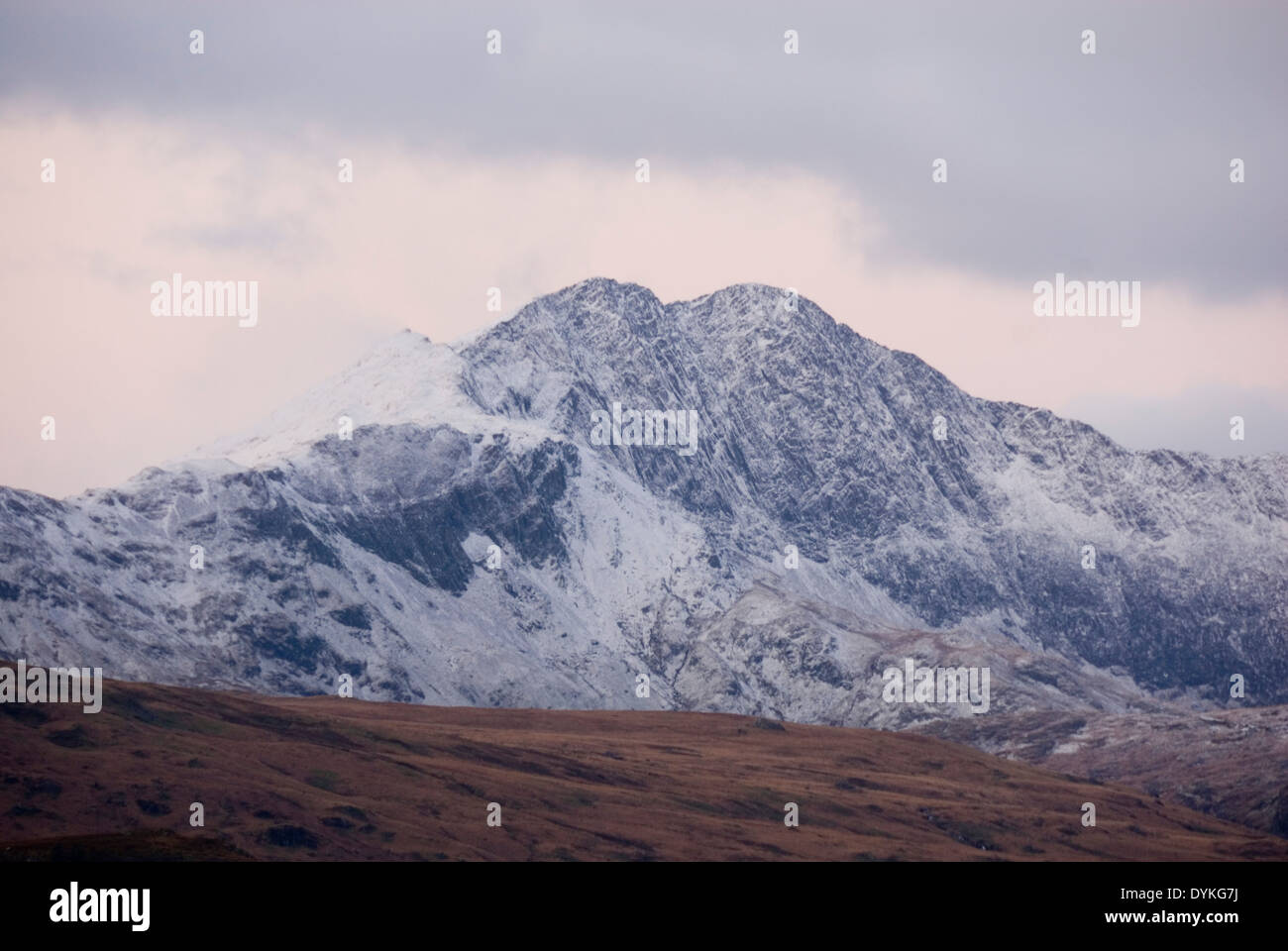 L'aube au mont Snowdon comme les nuages lever pour révéler une montagne couverte de neige sur un matin d'hiver, cercle de Snowdonia, Pays de Galles, Royaume-Uni Banque D'Images