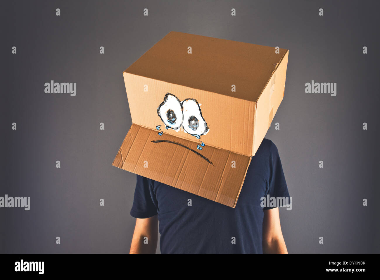 Homme avec boîte en carton sur la tête et visage pleurant triste expression. Concept de tristesse et dépression. Banque D'Images