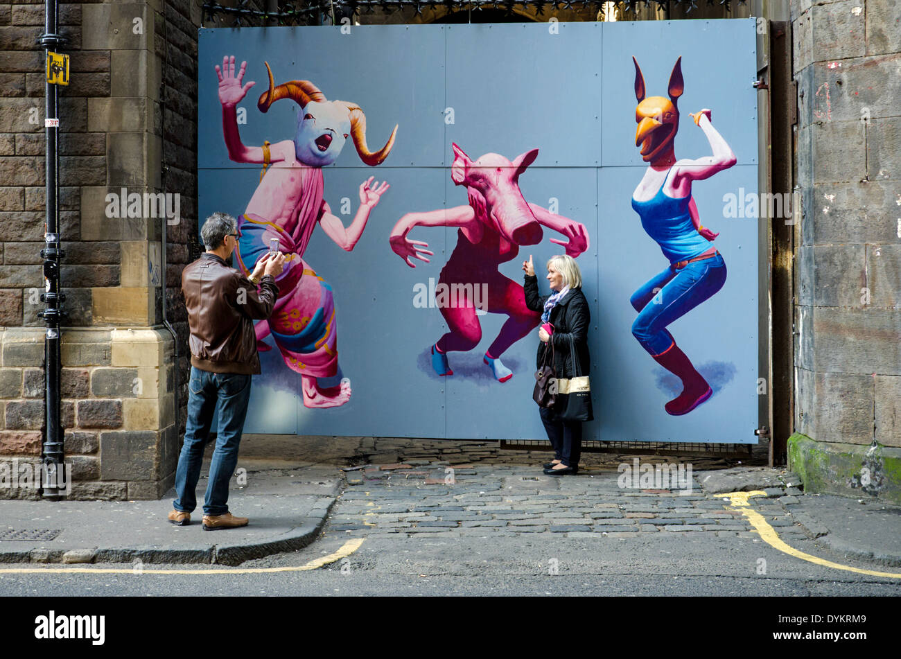 Les touristes posent par un morceau d'art urbain par Kirsty blanchir dans la région de Cowgate Edinburgh, Ecosse, Royaume-Uni. Banque D'Images